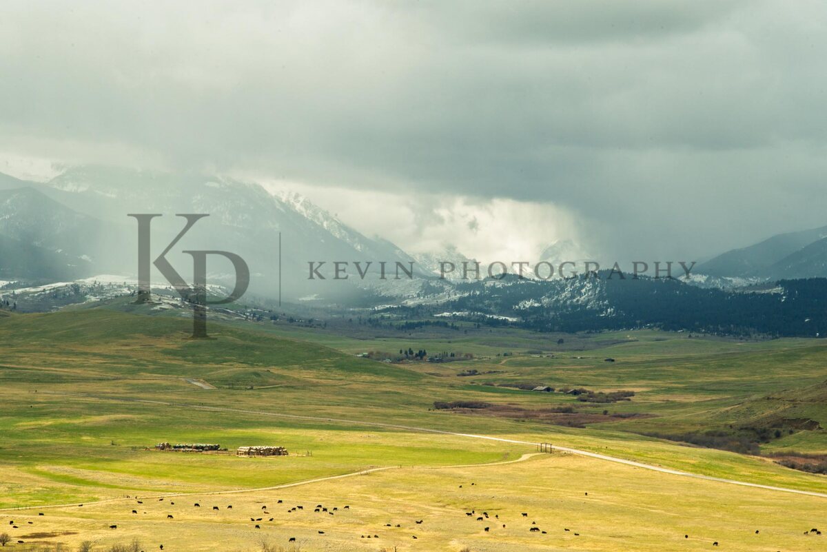 A wide Montana range beneath storm light and dark mountain skies.